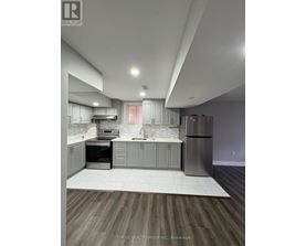 A modern kitchen with a refrigerator, sink, and oven.