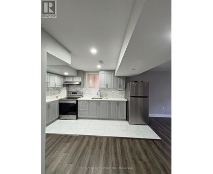 A modern kitchen with a refrigerator, sink, and oven.