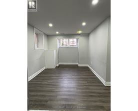 A room with wood flooring and white walls.