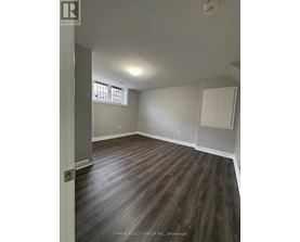 A room with wood flooring and a window.
