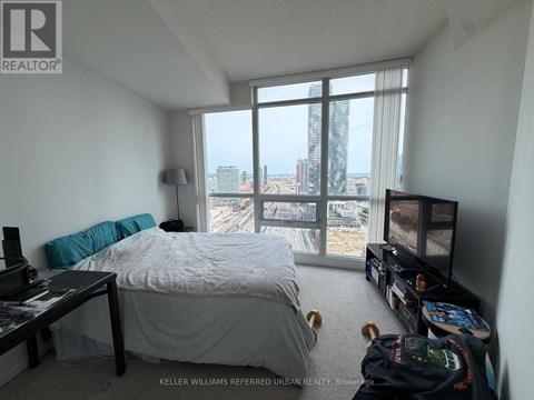 A bedroom with a large bed and a view of the city.