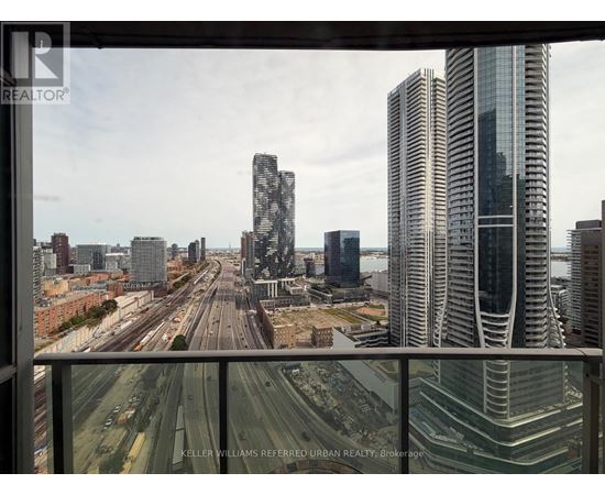 A cityscape with tall buildings and a highway in the foreground.