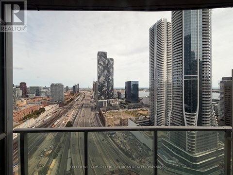 A cityscape with tall buildings and a highway in the foreground.