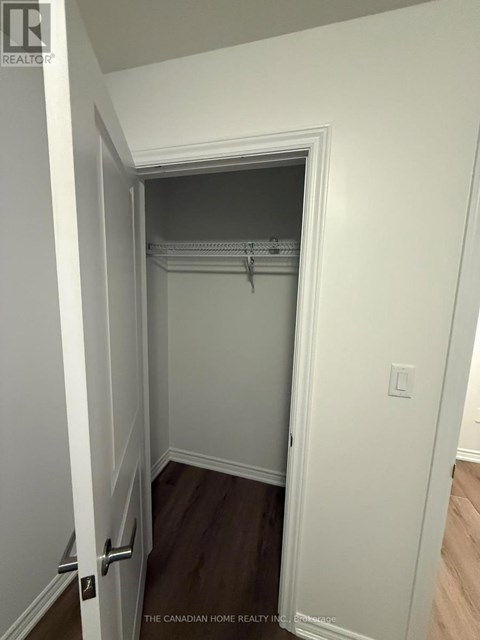 A white door with a handle is open to a small closet.