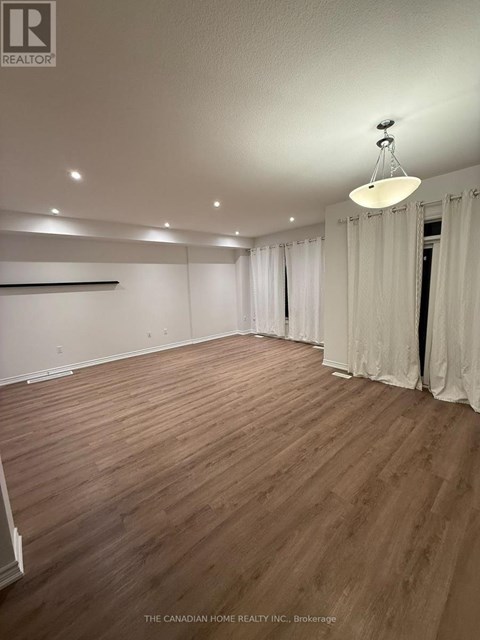 A room with wooden flooring and white walls.