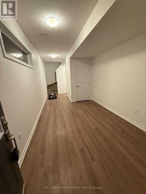 A hallway with wood floors and white walls.