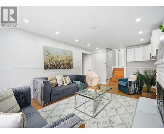 A living room with a grey couch and a glass coffee table.