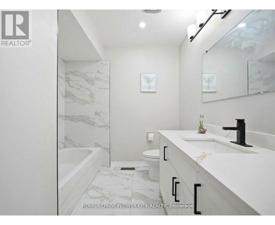 A white bathroom with a marble patterned tub and sink.