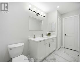 A white bathroom with a toilet, sink, and mirror.
