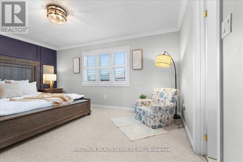 A bedroom with a bed, chair, and window.