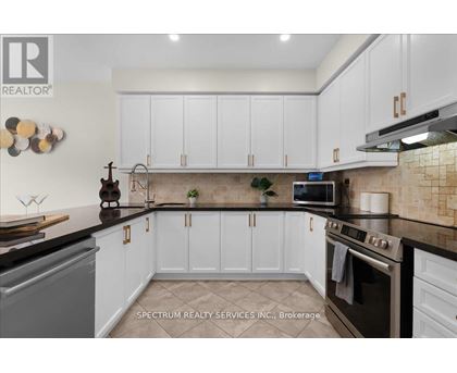 A kitchen with white cabinets and a black countertop.