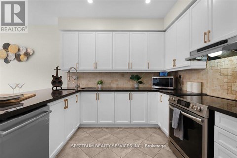 A kitchen with white cabinets and a black countertop.
