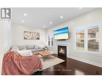A living room with a fireplace and a television on the wall.