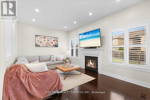 A living room with a fireplace and a television on the wall.