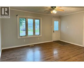 A room with a ceiling fan and wooden flooring.