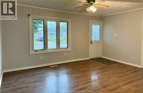A room with a ceiling fan and wooden flooring.