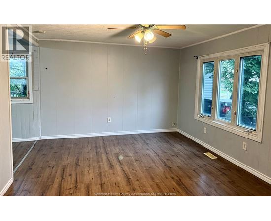A room with wooden floors and a ceiling fan.
