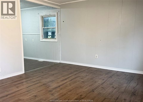 A room with wooden flooring and a window.