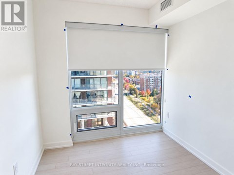 A room with a large window that has a view of a city.