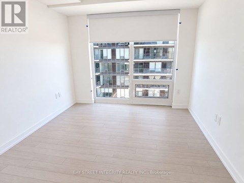 A room with a sliding glass door leading to a balcony.