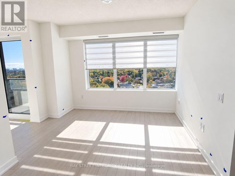 A sunny room with a view of the cityscape through the window.