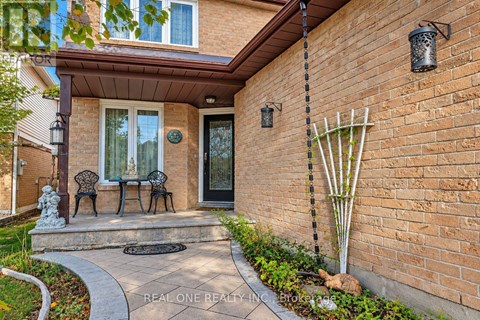 A brick house with a black door and a small porch.