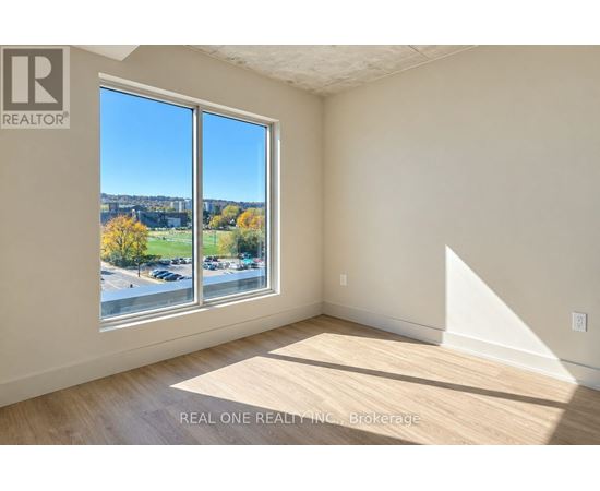 A room with a large window overlooking a parking lot.