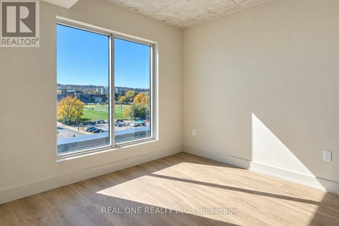 A room with a large window overlooking a parking lot.