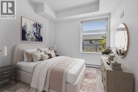 A bedroom with a large bed and a painting on the wall.
