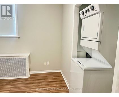 A small kitchen with a white oven and a radiator.