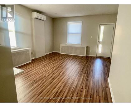 A room with wooden flooring and a window.