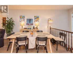 A dining room with a table set for four and chairs around it.