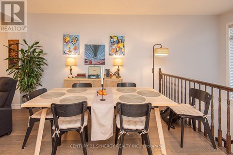 A dining room with a table set for four and chairs around it.