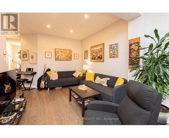 A living room with a grey couch and a guitar.