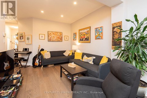 A living room with a grey couch and a guitar.