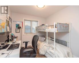 A bedroom with two bunk beds and a desk with a computer.