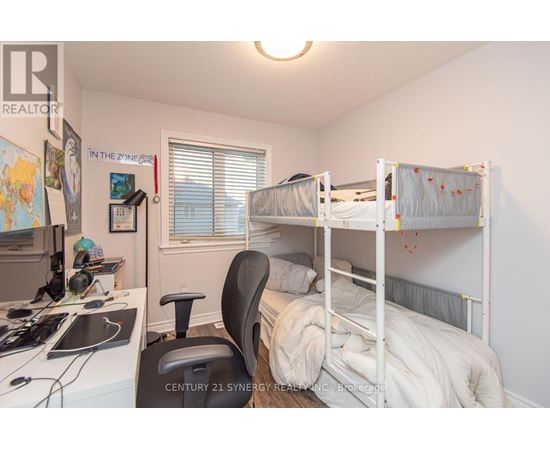 A bedroom with two bunk beds and a desk with a computer.