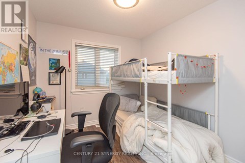 A bedroom with two bunk beds and a desk with a computer.