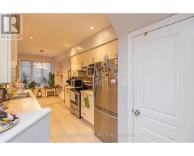 A kitchen with white cabinets and a white door.