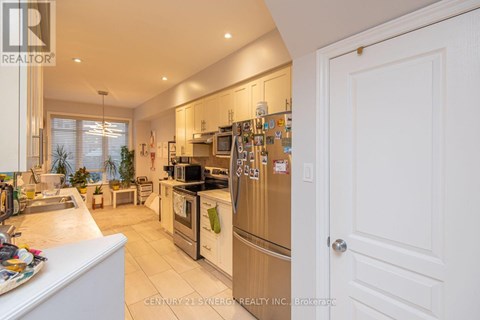 A kitchen with white cabinets and a white door.