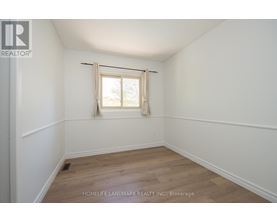 A room with a window and wooden flooring.