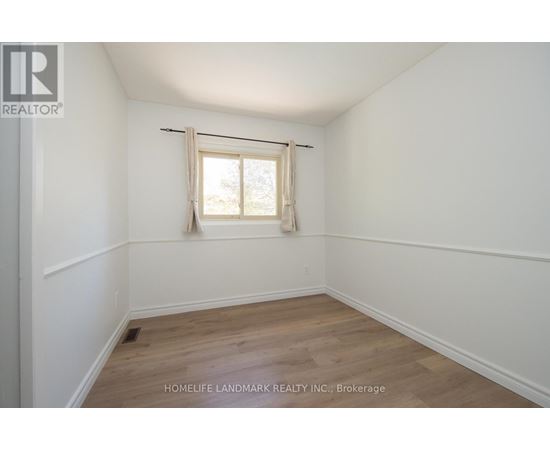 A room with a window and wooden flooring.