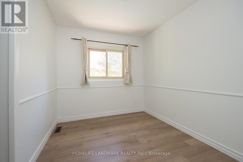 A room with a window and wooden flooring.