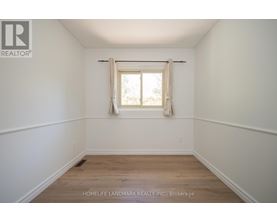 A room with a window and wooden flooring.