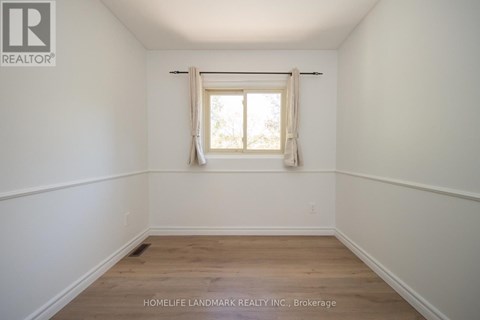 A room with a window and wooden flooring.