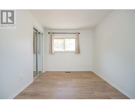 A room with a window and wooden flooring.