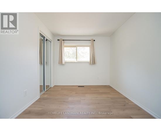 A room with a window and wooden flooring.