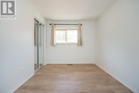 A room with a window and wooden flooring.