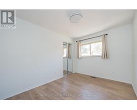 A room with a sliding glass door and a window with curtains.