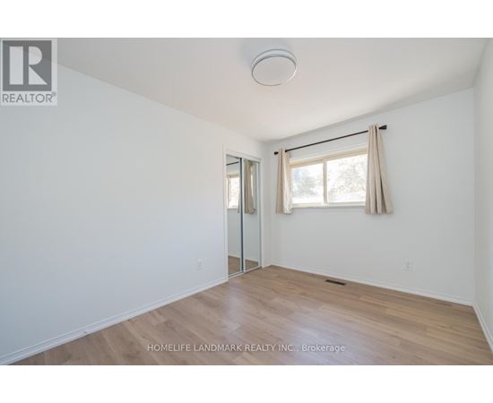 A room with a sliding glass door and a window with curtains.